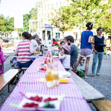 Auf dem Tuchollaplatz in Berlin wird eine lange Tafel für den Tag der Nachbarn aufgebaut (Bild: Christian Klant/ nebenan.de Stiftung)