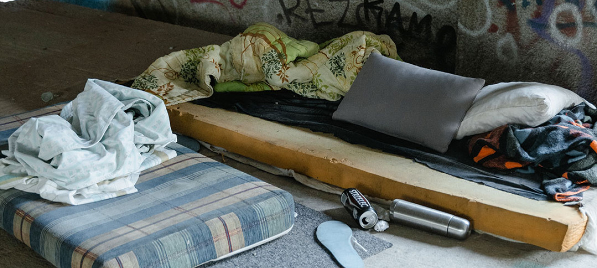 Matratzenlager von obdachlosen Menschen unter einer Brücke