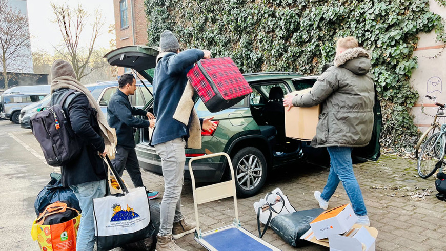 Nachbar:innen beladen ein Auto mit Spenden für Obdachlose